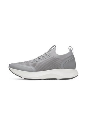Hellgrauer Sportschuh mit gestricktem Obermaterial, Schnürverschluss, weißer dicker gepolsterter Sohle und Zuglaschen an Zunge und Ferse, Seitenansicht auf weißem Hintergrund.