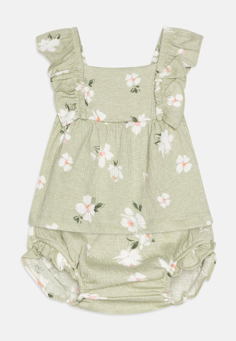 Robe florale vert clair avec des bretelles à volants, ornée de fleurs blanches et roses. Tissu doux avec un bas froncé et bouffant.