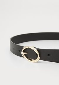 Zwarte leren riem met een gladde textuur, voorzien van een gedraaide metaalgesp in goudkleur en verschillende verstelgaten.