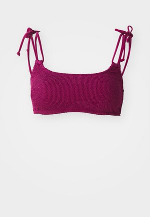 Magenta bralette with adjustable tie straps, textured knit pattern, rectangular shape, and a straight neckline.