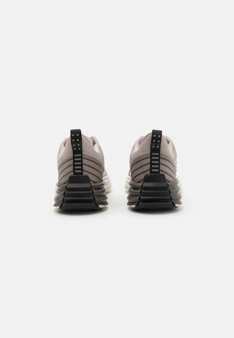 Zwei Sneakers mit einem grauen Mesh-Obermaterial und einer schwarzen Gummisohle, die horizontale Streifen an der Ferse und eine Schlaufe für einfaches Anziehen aufweisen.