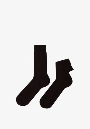 Calzini in cotone nero con una texture liscia, lunghezza classica alla caviglia e un bordo a coste, uno ripiegato.