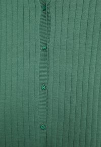 Texturerad grön cardigan med ett ribbat mönster, med fem gröna knappar fram.