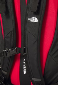 Must must värvi seljakott, millel on tekstureeritud kangas, reguleeritavad rihmad, klamber ja selgelt nähtav "THE NORTH FACE" logo.
