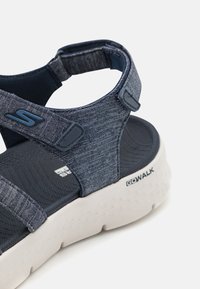 Sandali in tessuto blu navy con cinturini regolabili, suola imbottita e soletta testurizzata. Presentano una suola esterna in gomma bianca con il marchio "GOWALK".