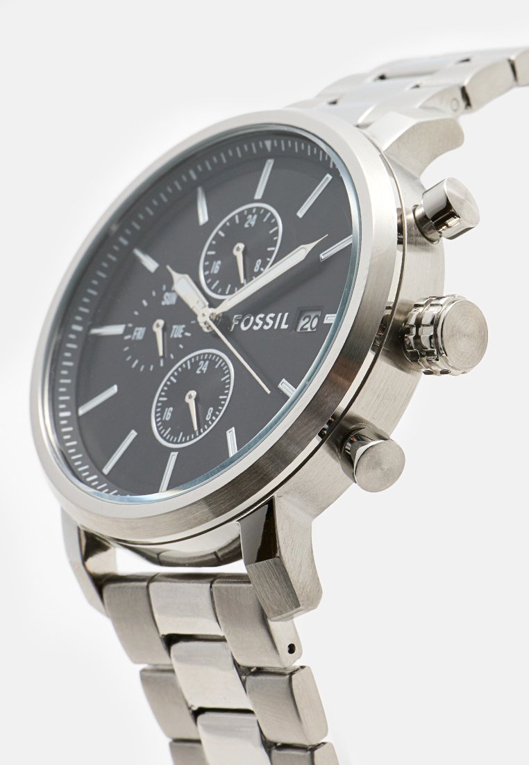 Fossil Edelstahl-Armbanduhr mit schwarzem Zifferblatt, drei Unterskalen, Datumsanzeige mit der Zahl 20 und Metallgliederarmband.