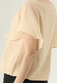 Zachte beige blouse van lichtgewicht chiffon met fluttermouwen, een relaxed fit en een lichte gathers aan de zoom. Heerlijke gladde textuur overal.