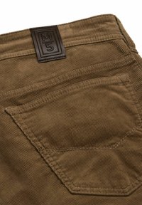 Pantalons en velours côtelé marron présentant une surface texturée, une poche à rabat au dos et une étiquette en cuir rectangulaire affichant "M5".