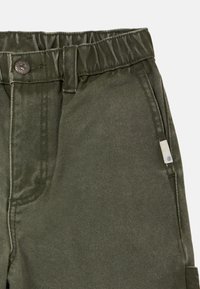 Pantalon en coton vert avec une taille froncée, fermeture à boutons et poches avant ; comprend une petite étiquette avec détail du logo.