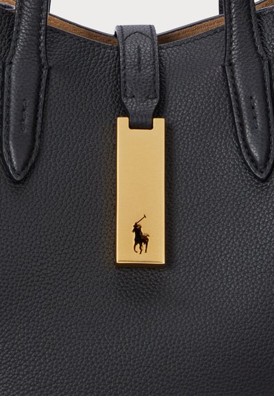 La borsa a mano nera in pelle presenta una finitura testurizzata, doppi manici e un'etichetta rettangolare dorata con un logo di un giocatore di polo in nero.