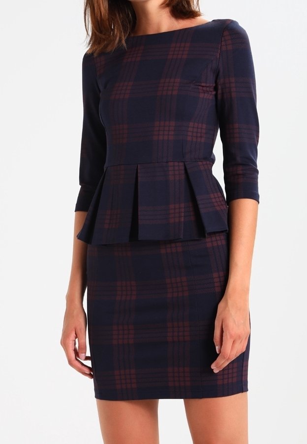 Robe bleu marine à manches trois-quarts, taille peplum et motif à carreaux bordeaux. Tissu lisse avec une silhouette cintrée.