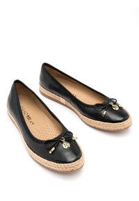 Ballerine in pelle nera con suola in giuta intrecciata, caratterizzate da punta arrotondata, piccolo fiocco decorativo e dettagli in hardware color oro.