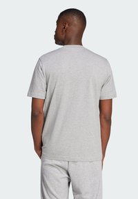 Γκρι κοντομάνικη μπλούζα φτιαγμένη από μαλακό ύφασμα, με στρογγυλή λαιμόκοψη και άνετη εφαρμογή, παρουσίασε έναν απλό σχεδιασμό χωρίς ορατά μοτίβα.