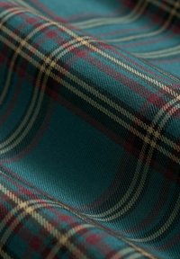 Geweven stof met een teal basis en een ruitpatroon in bordeauxrood en goud. De textuur is glad met een lichte glans.