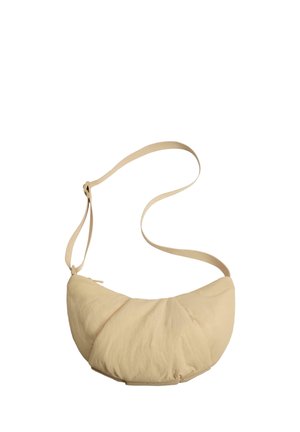 Beige schoudertas in halve maanvorm met verstelbare riem en ritssluiting, gemaakt van zachte, gestructureerde stof.