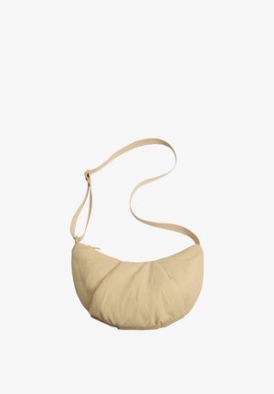 Beige schoudertas in halve maanvorm met verstelbare riem en ritssluiting, gemaakt van zachte, gestructureerde stof.