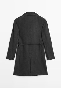 Grå frakke med nålestriber, klassisk krave, lange ærmer og bælte i taljen. Fremstillet af et struktureret stof med skræddersyet pasform og slids bagpå.