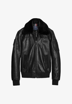 Veste bomber en cuir noir avec un col en fourrure, fermeture éclair à l'avant, poignets côtelés et deux poches avant. Présente un badge sur la poitrine et le bras.