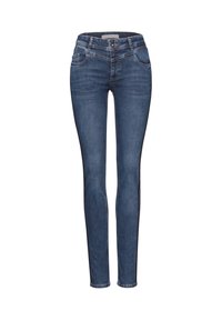 Tummansiniset naisten slim fit -farkut, joissa on etupainike, vetoketju, vyölenkit ja viiden taskun muotoilu valkoisella taustalla.