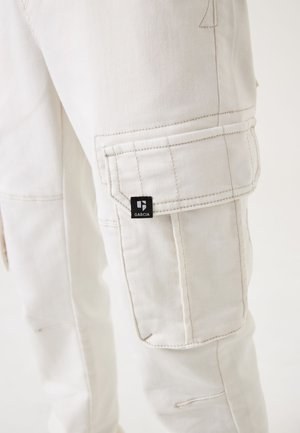 Pantalons cargo blancs en tissu texturé, dotés de plusieurs poches et de quincaillerie noire. Étiquette de marque "GARCIA" visible sur la poche latérale.