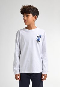 T-shirt bianca a maniche lunghe con una grafica blu sul lato sinistro del petto, che presenta testo e forme astratte. Tessuto in cotone, vestibilità rilassata.
