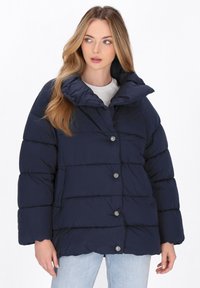 Giacca puffer blu navy con colletto alto, design trapuntato e bottoni argentati. Il tessuto ha una superficie liscia, ideale per il calore.
