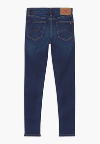 Vaqueros de mezclilla azul oscuro con textura suave, piernas rectas y dos bolsillos traseros con un diseño de costuras. Etiqueta en la cintura.