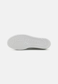Semelle de chaussure en caoutchouc blanc avec un motif texturé et le nom de marque gravé "Paul Green". Présente une forme arrondie et une légère courbure.