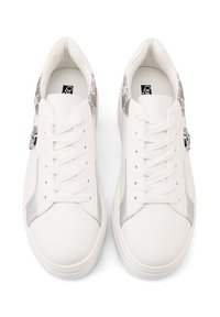 Sneakers bianchi con tomaia in pelle liscia, dettagli in pelle argentata sui lati e parte posteriore in tessuto con motivo. Presentano lacci piatti e una punta arrotondata.