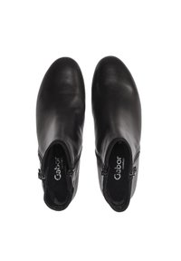 Botas de tobillo de cuero negro con un acabado suave, que cuentan con cremalleras laterales para ponerlas y quitarlas fácilmente. Diseñadas con punta redonda y tacón bajo.
