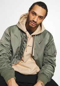 Karl Kani UNISEX SMALL SIGNATURE HOODY  - Sweatshirt com capuz - sand
