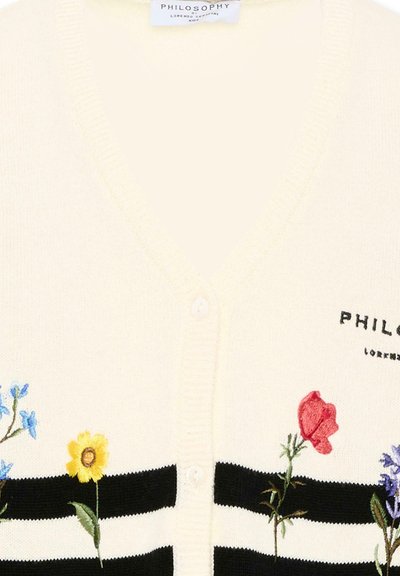 Crèmekleurige gebreide cardigan met zwarte horizontale strepen en geborduurde blauwe, gele, rode en paarse bloemen langs de voorkant.