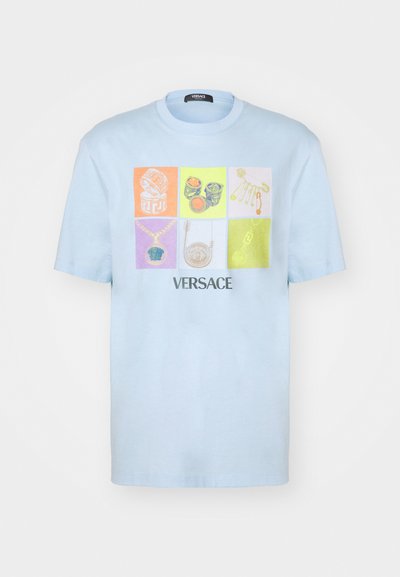 Ljusblå t-shirt med ett collage av smycketeckningar i olika färger, med "VERSACE" tryckt längst ner.