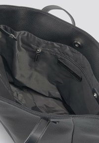 Crna torba na rame s teksturiranim kožnim vanjskim dijelom i glatkim unutrašnjim dijelom, s patentnim zatvaračem i kopčanjem na dugme.