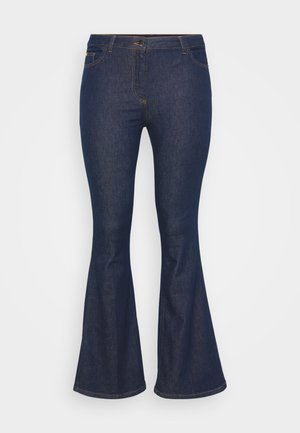 Bredde mørkeblå jeans laget av denim, med en tettsittende midje, glidelås, og subtile stikkdetaljer. Beina utvider seg nederst.