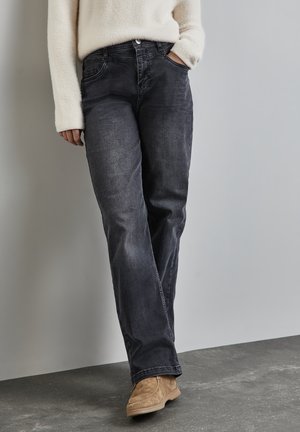 Jeans en denim foncé avec une coupe droite, présentant une fermeture à bouton sur le devant, des poches latérales et une texture légèrement délavée.