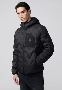 Giacca a vento nera con cappuccio, dotata di zip frontale, motivo trapuntato esagonale e taschino sul petto con patch-logo.