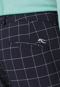 Mornarsko karirane hlače s bijelom mrežicom, sa stražnjim džepom i izvezenim logotipom. Glatki materijal, ravnog kroja i urednog šivanja.