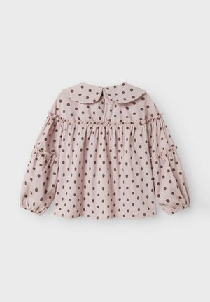 Ljusrosa blus med stora bruna prickar, med en rundad krage, vevad midja och puffärmar med elastiska manschetter.