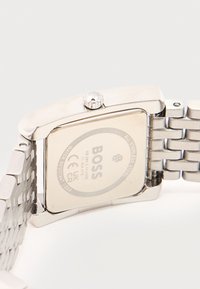 Πίσω μέρος ρολογιού χειρός BOSS από ανοξείδωτο ατσάλι που δείχνει τον αριθμό μοντέλου, αντοχή στο νερό 3 BAR και τα συνδέσμους του βραχιολιού από ανοξείδωτο ατσάλι.