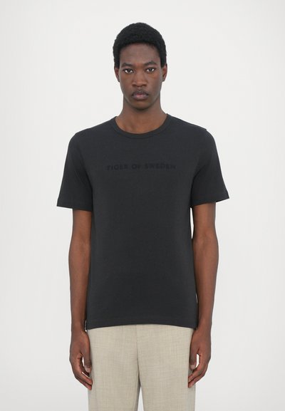 Black short-sleeve T-shirt featuring a crew neck and embossed "TIGER OF SWEDEN" logo on the front, made from smooth cotton fabric.