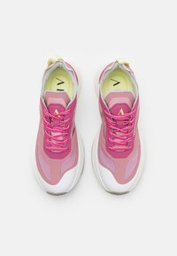 Scarpe da ginnastica rosa con sovrapposizioni in rete e sintetico, suole bianche e lacci rosa. Le sole interne gialle presentano un design con logo.
