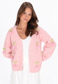 Rosa stickad cardigan med körsbärsbroderi i rosa och grönt. Har en V-ringning och öppen front, med långa, avslappnade ärmar.