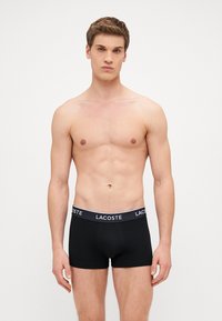 Czarne bokserki męskie wykonane z bawełny, z szerokim elastycznym paskiem w talii z logo "Lacoste". Prosty, dopasowany krój.