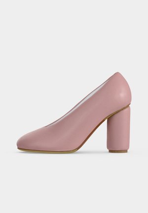 Escarpin rose blush pour femme avec bout arrondi et talon haut épais sur fond blanc uni.
