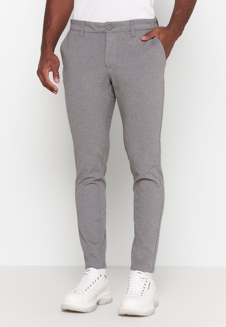 Gray tailored trousers made of textured fabric, featuring a slim fit, side pockets, and a smooth waistband, paired with white sneakers.