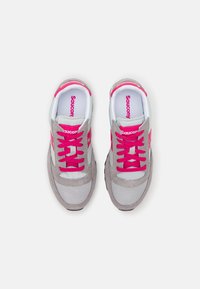 Saucony sneakers har en overdel i gråt ruskind og mesh, lyserøde snørebånd og detaljer, hvid branding og en tekstureret, sort gummisål.
