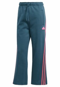Tyrkysové tepláky s krajkovým pasem, bočními kapsami a třemi růžovými proužky po stranách nohavic. Má logo značky Adidas.