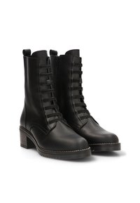 Botas de ankle de cuero negro con punta redonda, que cuentan con cordones en la parte delantera y cremallera lateral. Tacón cuadrado con suela texturizada.