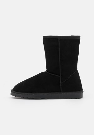 Black suede ankle boots with a rounded toe, smooth texture, and a flat rubber sole. No visible hardware or patterns.